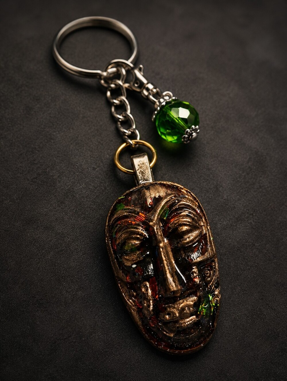 Artisan Bronze Mask Keychain with Green Crystal Accent